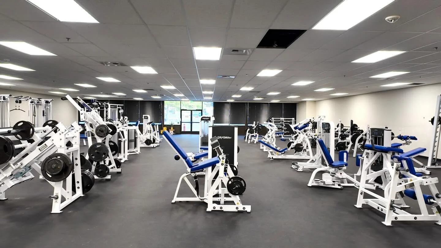NCE's Personal Fitness Trainer training floor with rows of Hammer Strength plate-loaded equipment